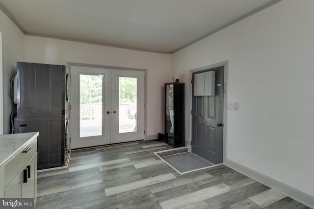 foyer entrance featuring ornamental molding, light hardwood / wood-style floors, and french doors