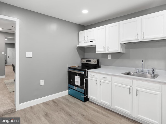 kitchen featuring white cabinets, a sink, stainless steel range with electric stovetop, under cabinet range hood, and baseboards