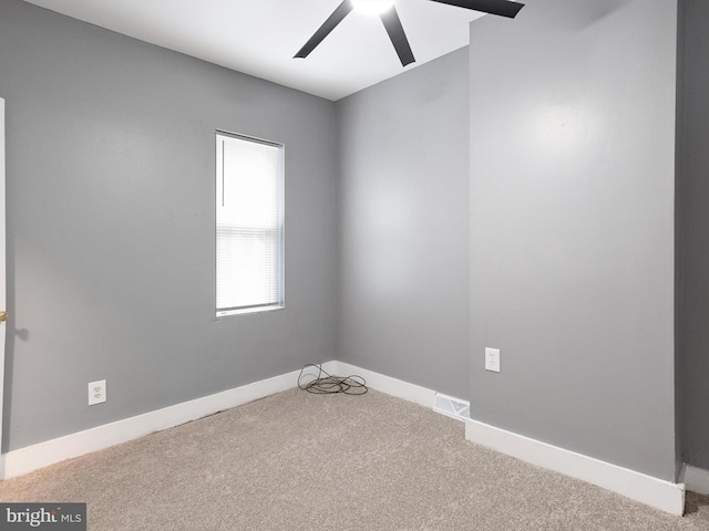 empty room featuring carpet flooring, ceiling fan, and baseboards