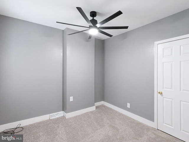 empty room with carpet, visible vents, ceiling fan, and baseboards