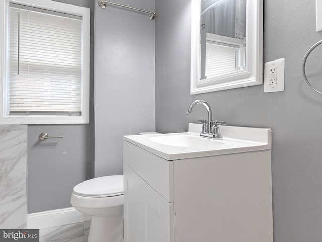 bathroom featuring toilet, marble finish floor, and vanity