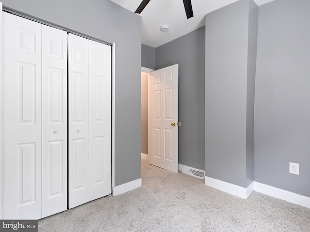 unfurnished bedroom featuring carpet, visible vents, baseboards, and a closet