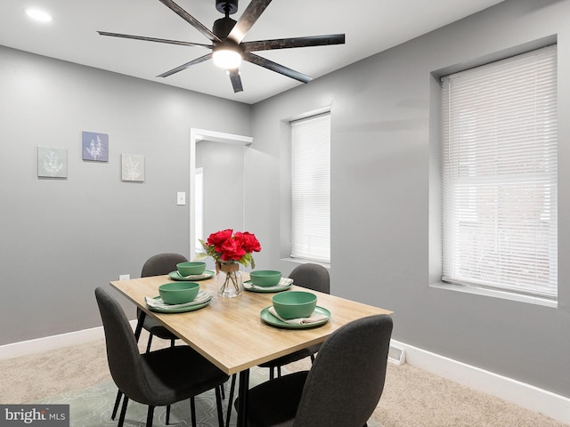 dining space with light carpet, baseboards, and a ceiling fan