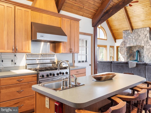 kitchen with wood ceiling, beamed ceiling, ventilation hood, a kitchen bar, and a center island with sink