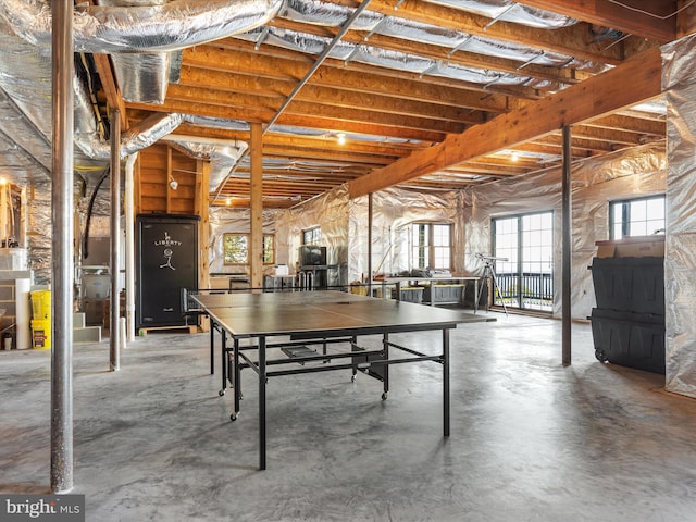 recreation room with concrete flooring and gas water heater