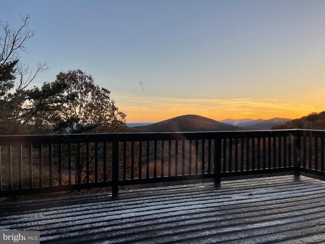 deck at dusk featuring a mountain view