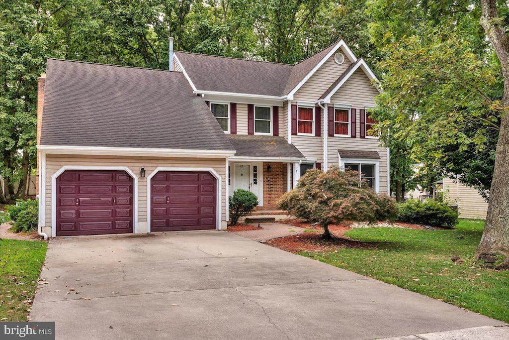 traditional-style home with driveway, a shingled roof, an attached garage, and brick siding