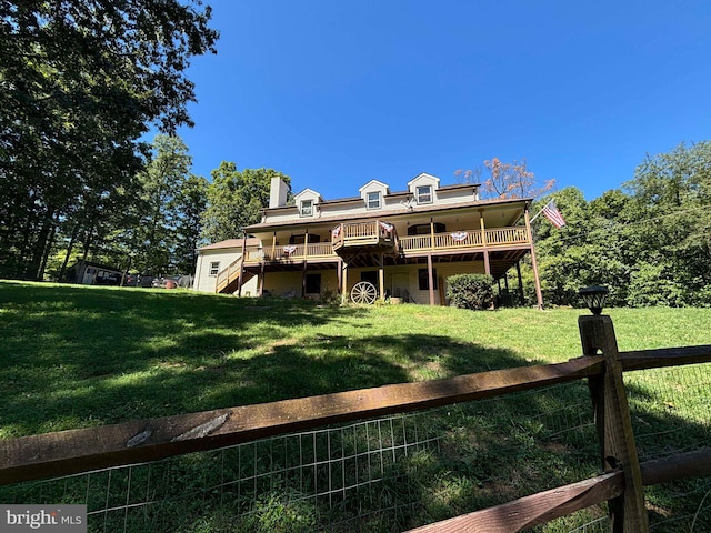 rear view of house featuring a yard and a deck