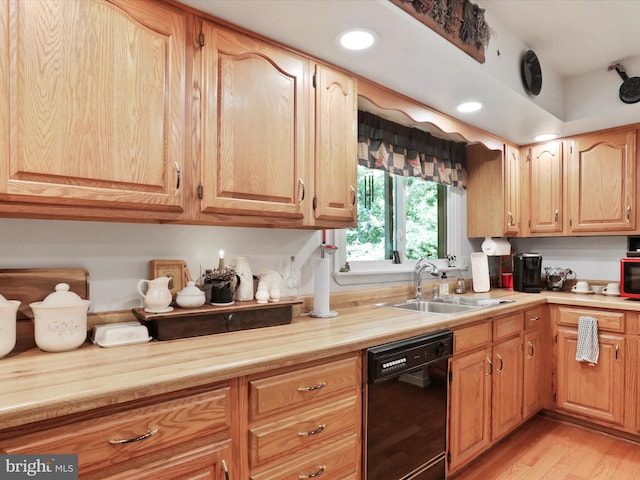 kitchen featuring black dishwasher, sink, and light wood-type flooring