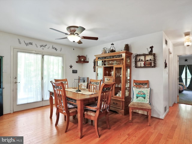 dining area with light wood-type flooring and ceiling fan