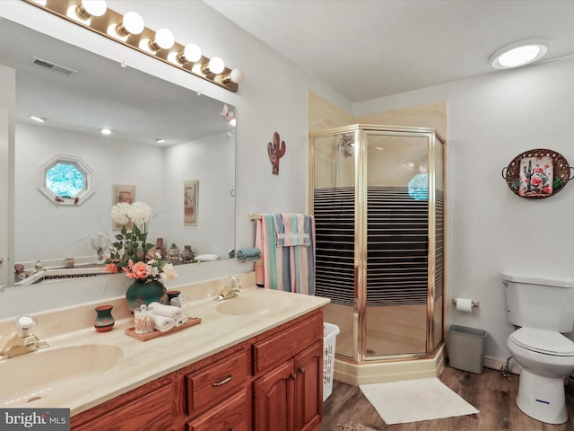 bathroom featuring vanity, toilet, hardwood / wood-style flooring, and a shower with door