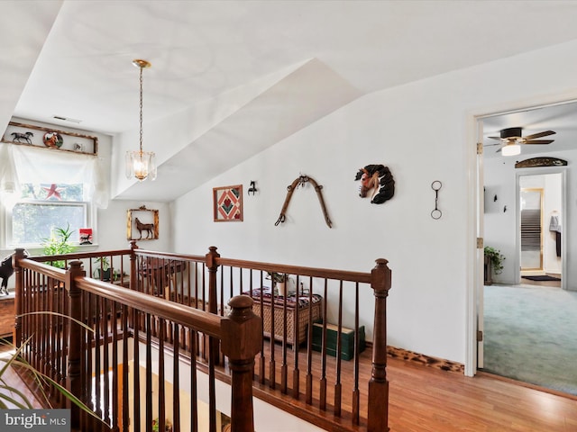 hallway with lofted ceiling, light hardwood / wood-style flooring, and a notable chandelier