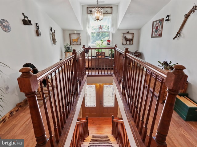 staircase featuring hardwood / wood-style floors and a notable chandelier