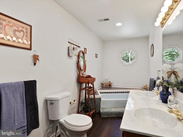 bathroom with vanity, toilet, wood-type flooring, and a bathtub