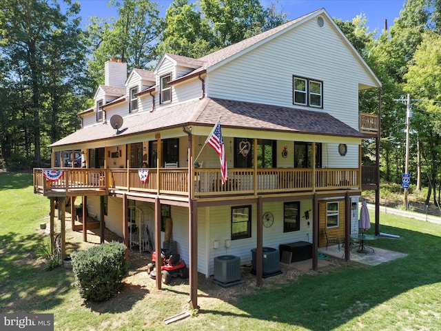 back of property featuring central AC unit, a yard, a wooden deck, and a patio