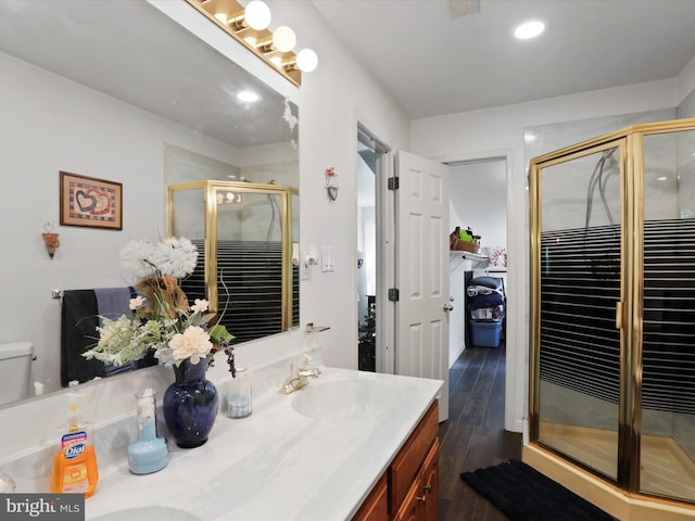 bathroom with vanity, toilet, hardwood / wood-style floors, and walk in shower