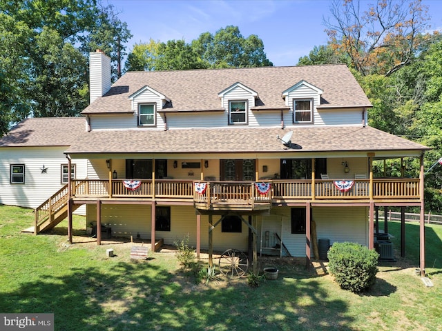 rear view of property featuring central AC, a wooden deck, and a yard