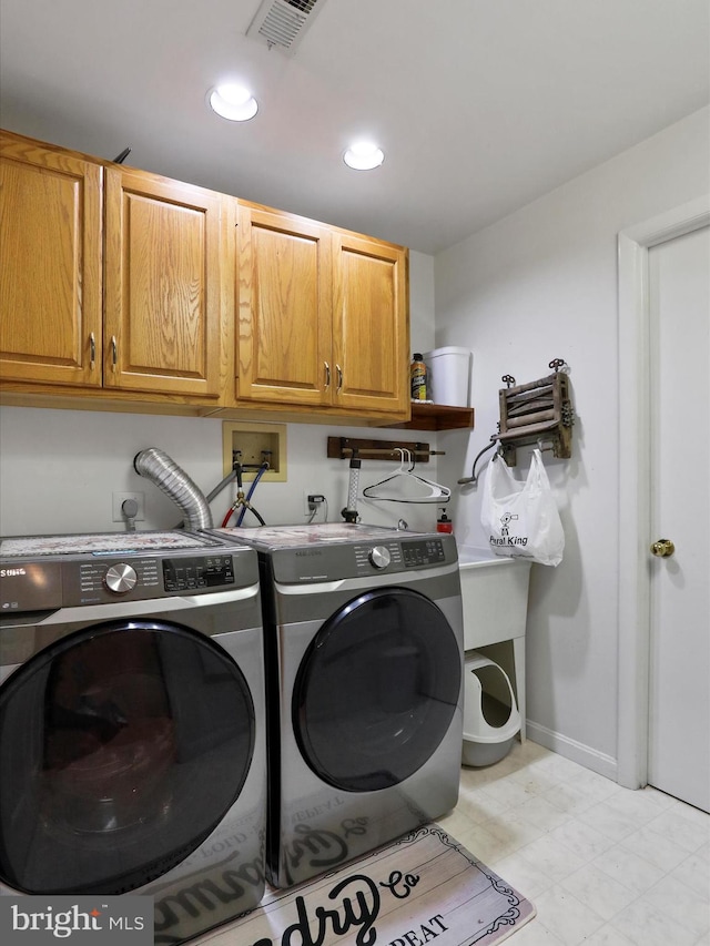 laundry area featuring cabinets and washing machine and dryer