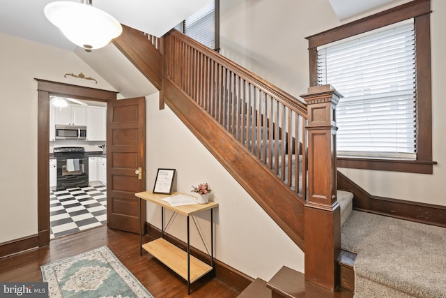 stairs featuring vaulted ceiling and hardwood / wood-style floors