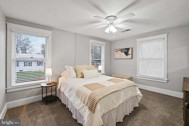 carpeted bedroom featuring ceiling fan and multiple windows