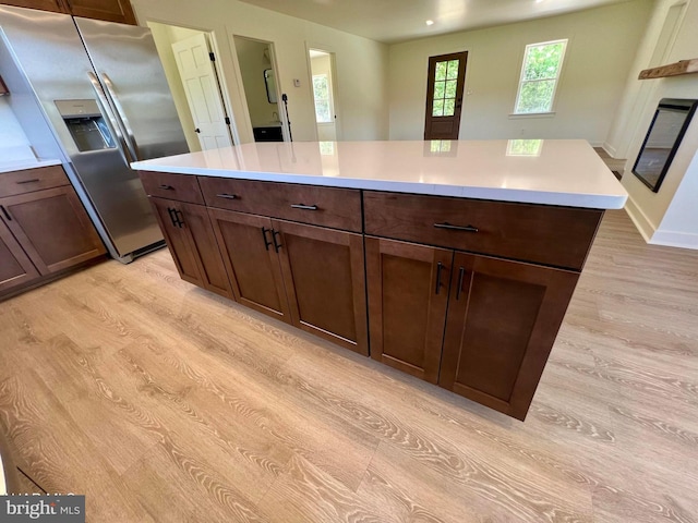 kitchen featuring stainless steel fridge, a center island, and light hardwood / wood-style flooring