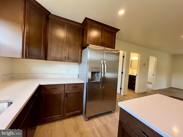 kitchen featuring stainless steel fridge with ice dispenser, dark brown cabinets, and light hardwood / wood-style flooring