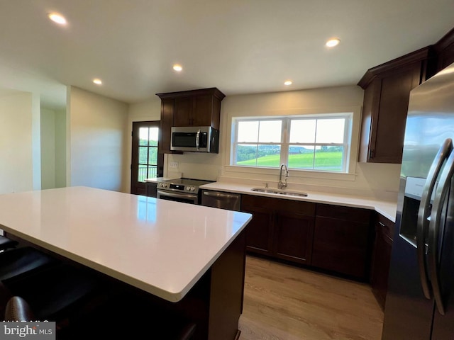 kitchen with plenty of natural light, stainless steel appliances, sink, and light wood-type flooring