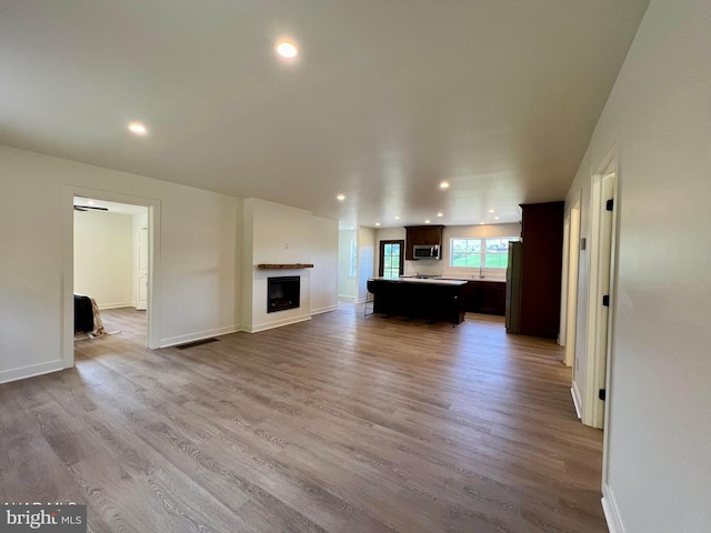 unfurnished living room with light wood-type flooring and billiards