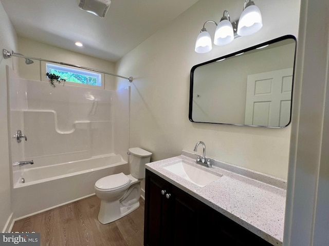 full bathroom with vanity, toilet, washtub / shower combination, and hardwood / wood-style floors