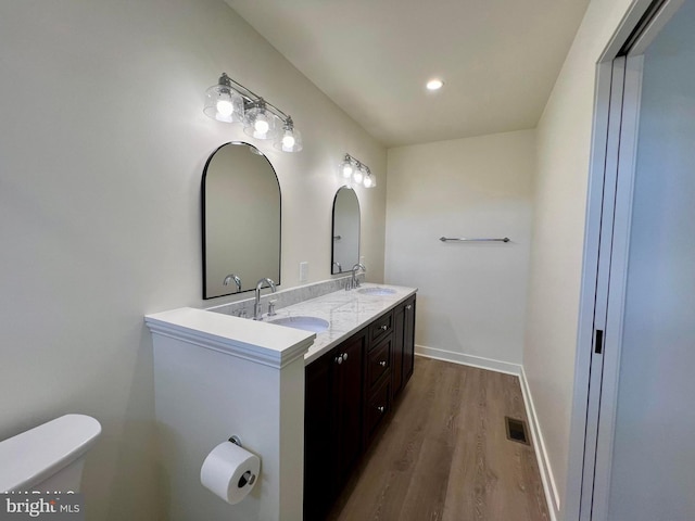 bathroom with hardwood / wood-style floors, toilet, and vanity