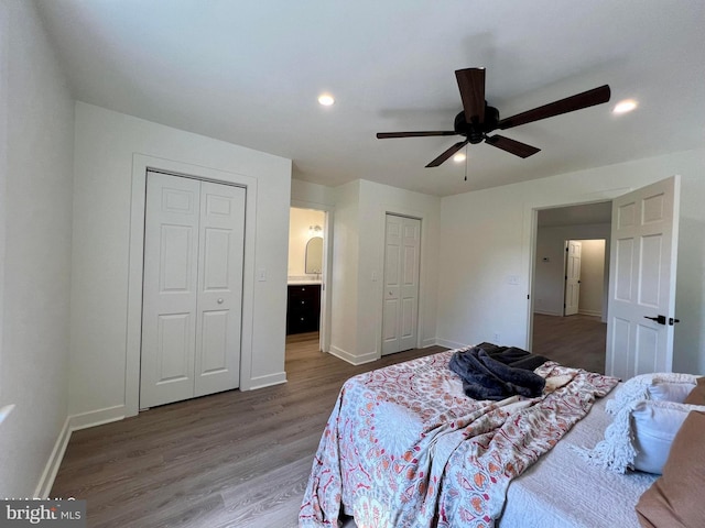 bedroom with ceiling fan, connected bathroom, and wood-type flooring