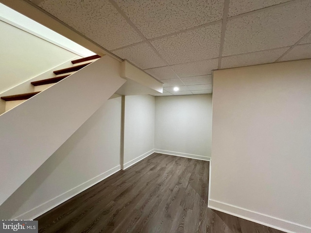 basement featuring wood-type flooring and a drop ceiling