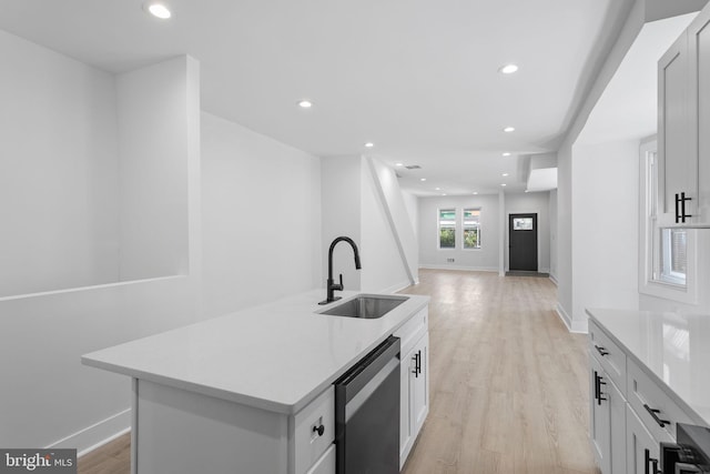 kitchen featuring light hardwood / wood-style floors, stainless steel dishwasher, a center island, sink, and white cabinets