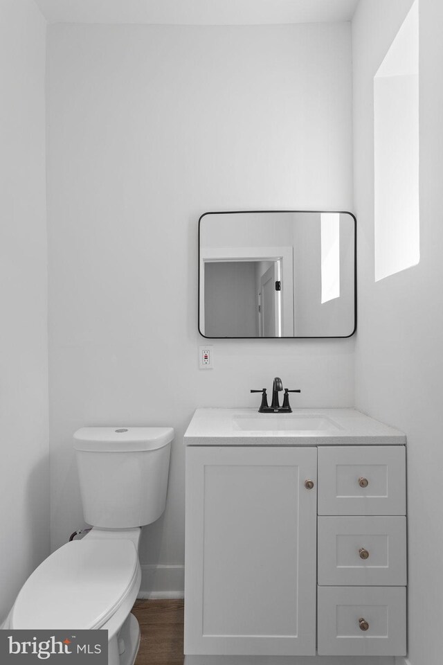 bathroom with vanity, toilet, and hardwood / wood-style flooring