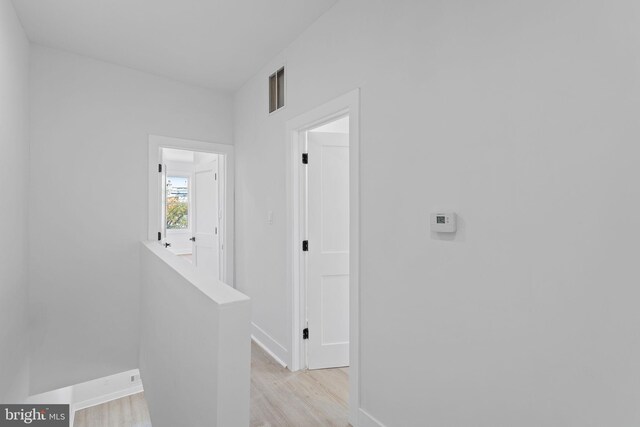 hallway with light hardwood / wood-style flooring