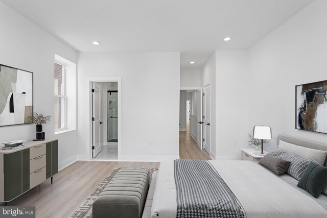 bedroom with light wood-type flooring and ensuite bath