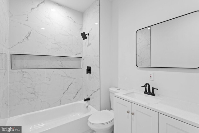 full bathroom featuring tiled shower / bath, toilet, and vanity