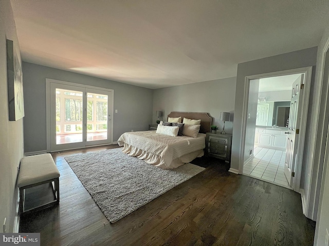 bedroom featuring access to exterior, ensuite bathroom, baseboards, and dark wood-style flooring