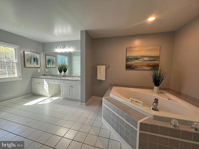 bathroom featuring tile patterned flooring, double vanity, a bath, and a sink