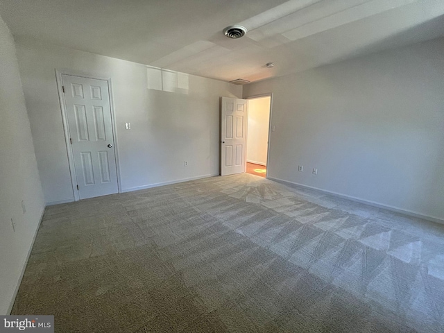 unfurnished room featuring carpet, visible vents, and baseboards