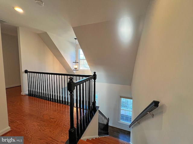 staircase featuring wood finished floors and baseboards