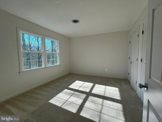 unfurnished bedroom with carpet flooring, baseboards, and visible vents