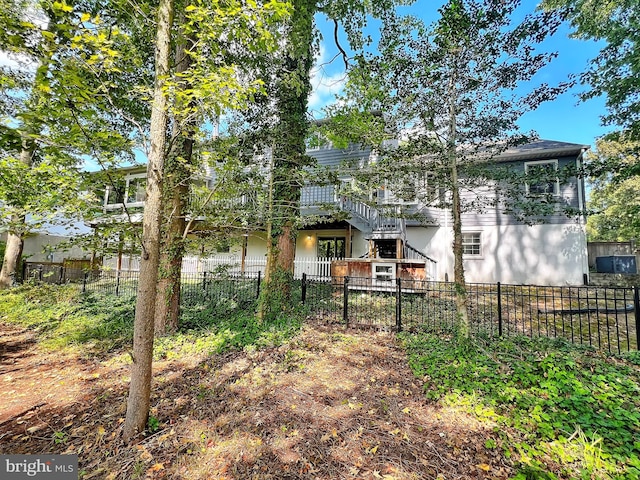 back of property with fence private yard and stairs