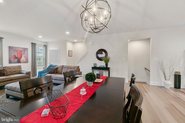 dining space with a notable chandelier, baseboards, wood finished floors, and recessed lighting