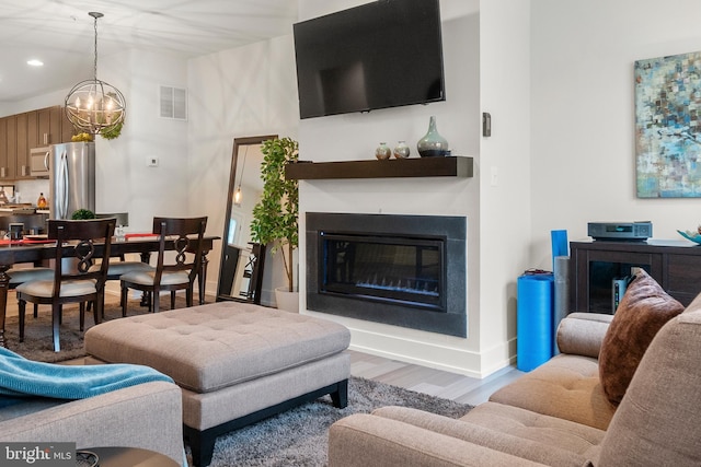 living room with recessed lighting, wood finished floors, visible vents, baseboards, and a glass covered fireplace