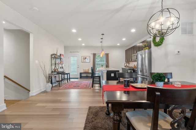 dining room featuring recessed lighting, visible vents, baseboards, light wood-style floors, and an inviting chandelier