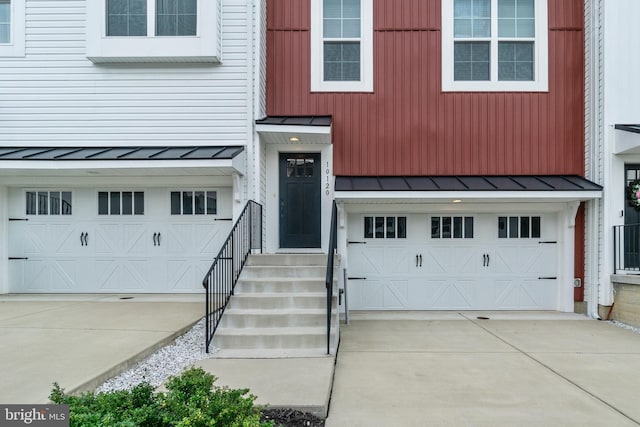 entrance to property featuring metal roof, a standing seam roof, and an attached garage