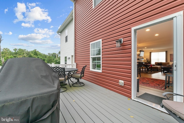 deck with a grill and outdoor dining space