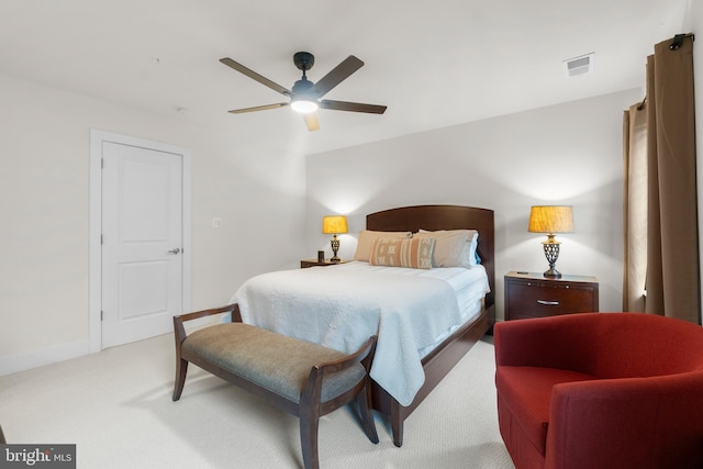 bedroom featuring a ceiling fan, visible vents, light carpet, and baseboards