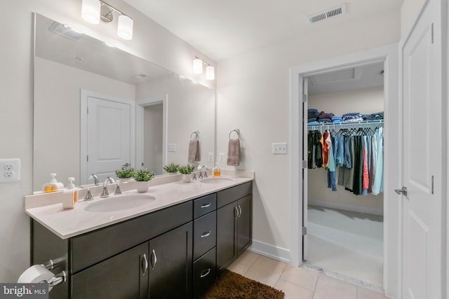 bathroom featuring double vanity, visible vents, a sink, and tile patterned floors